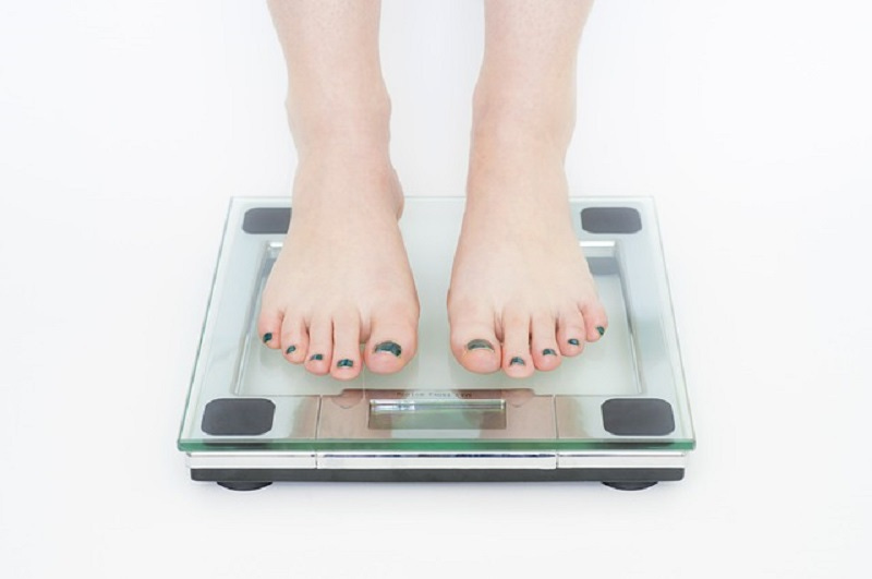 woman on weight scales with black toe nail polish