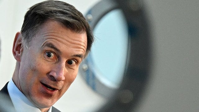 Britain's Chancellor of the Exchequer Jeremy Hunt speaks at a fringe event behind a door with round windows at the annual Conservative Party Conference in Manchester, northern England, on October 3, 2023. (Photo by Oli SCARFF / AFP) (Photo by OLI SCARFF/AFP via Getty Images)