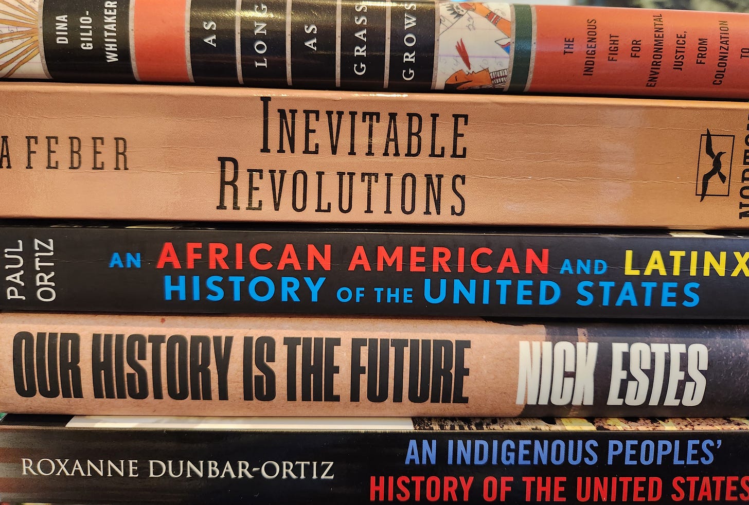 stack of books about Indigenous history, African American history, and US foreign policy
