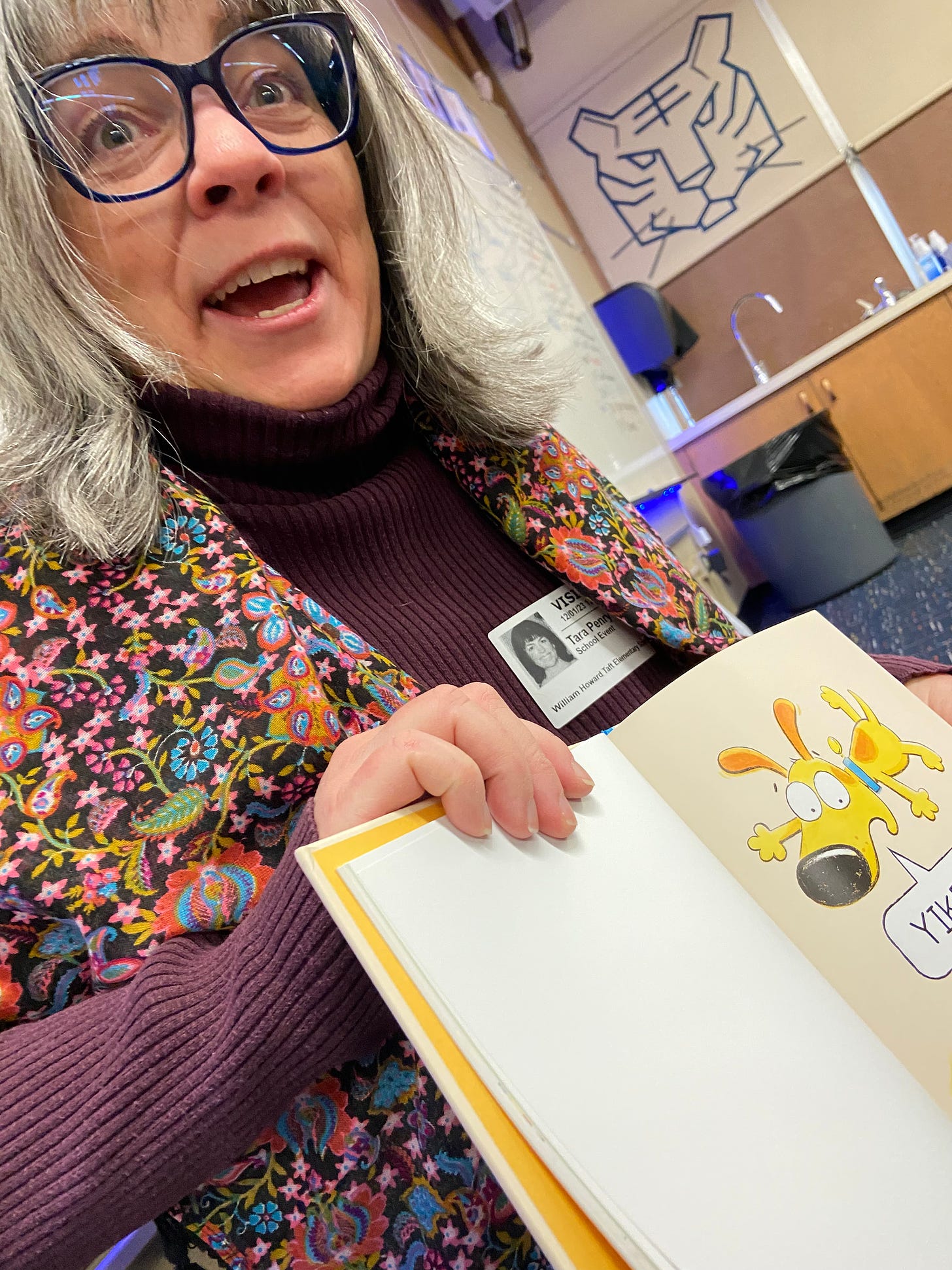 Crazy lady with big glasses (me) mirroring the expression of an animated dog in a book saying "Yikes!"