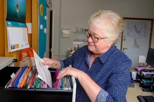 Free Elderly Woman Browsing Files Stock Photo