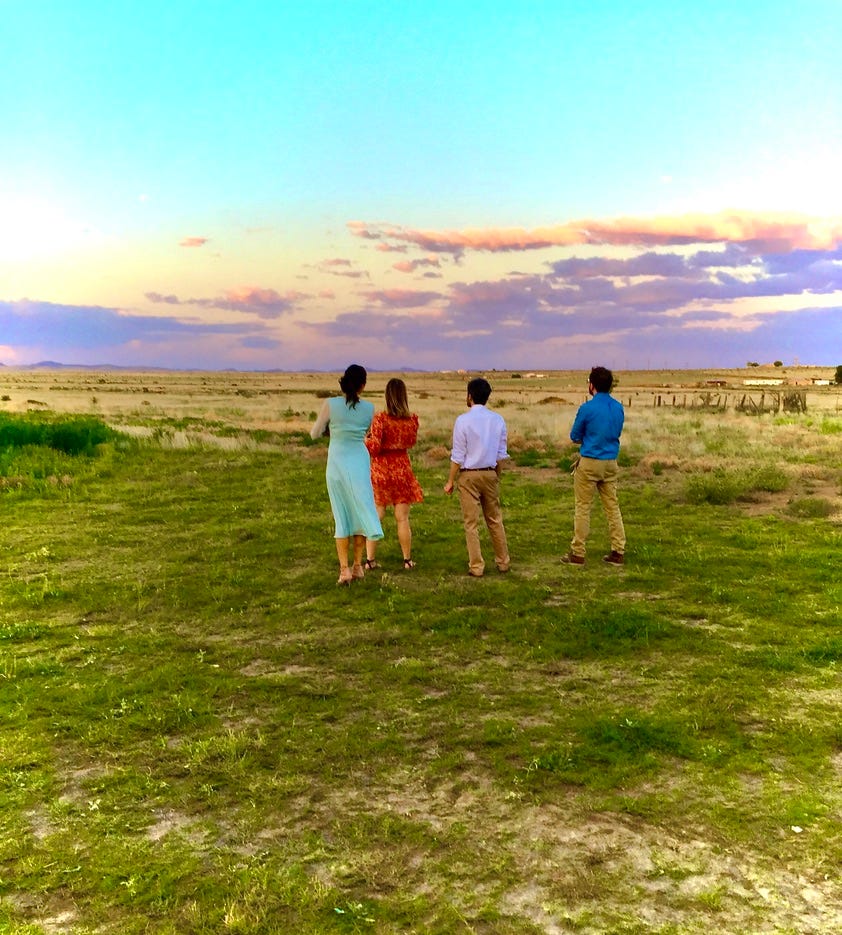 A group of people standing in a field

Description automatically generated