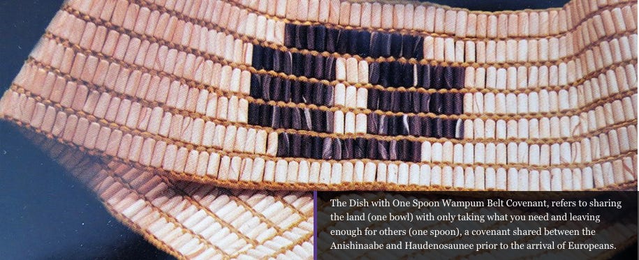 Close-up of purple beads woven in a circle in the center of a white wampum belt