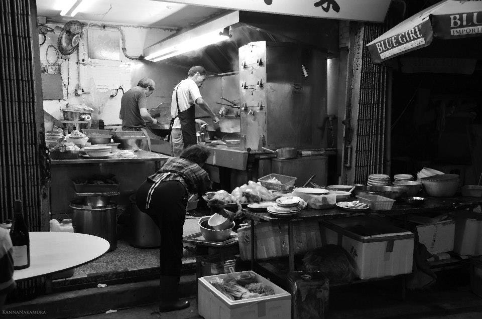 Black and white photo of a busy Chinese restaurant kitchen