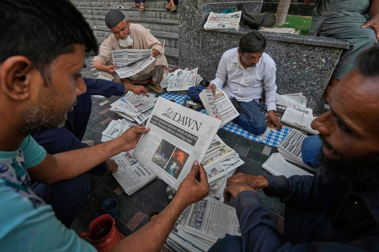 People read morning newspapers leading with the story of India firing missiles into Pakistan and Pakistan-administered Kashmir, in Karachi, Pakistan.