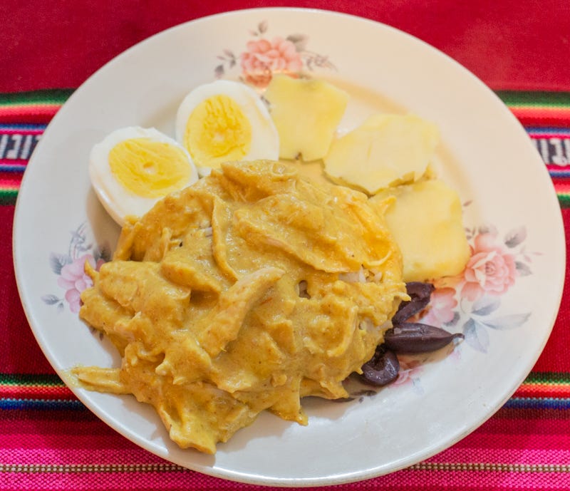 Ají de Gallina, a traditional chicken stew made with Peruvian yellow peppers and chicken, garnished with boiled eggs and olives