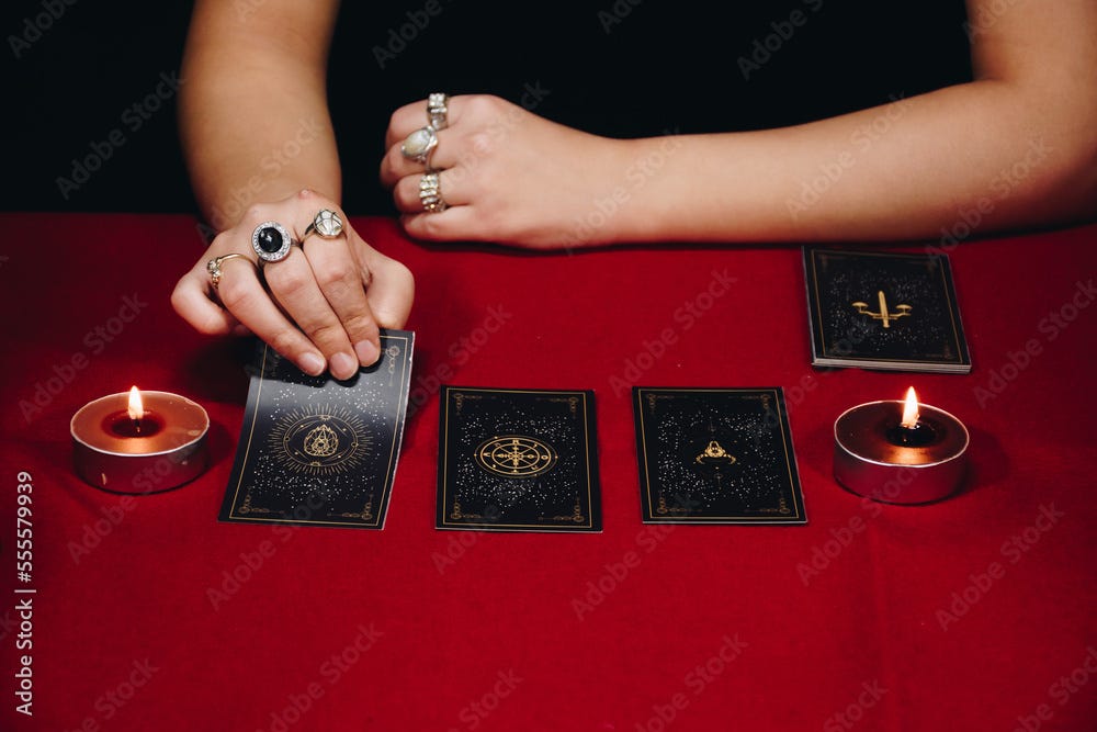 Tarot reader picking tarot cards. Tarot cards face down on the table near  burning candles. Candlelight in dark.Tarot reader or Fortune teller reading  and forecasting concept. Photos | Adobe Stock