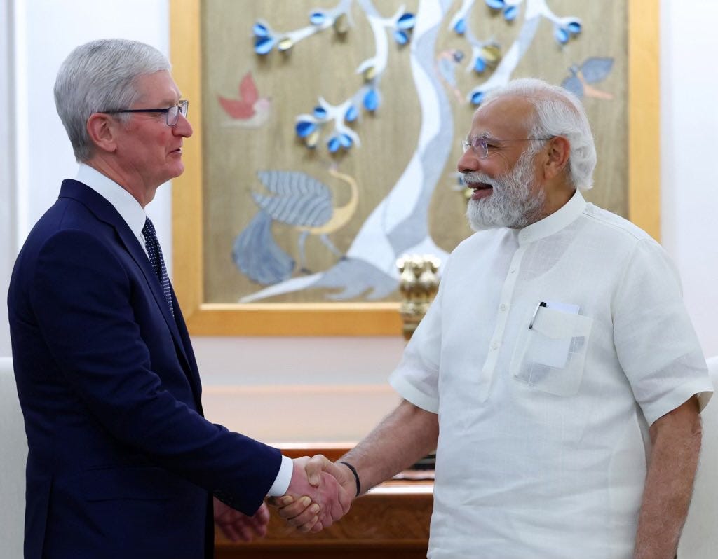 Apple CEO Tim Cook shakes hands with India Prime Minister Narendra Modi.