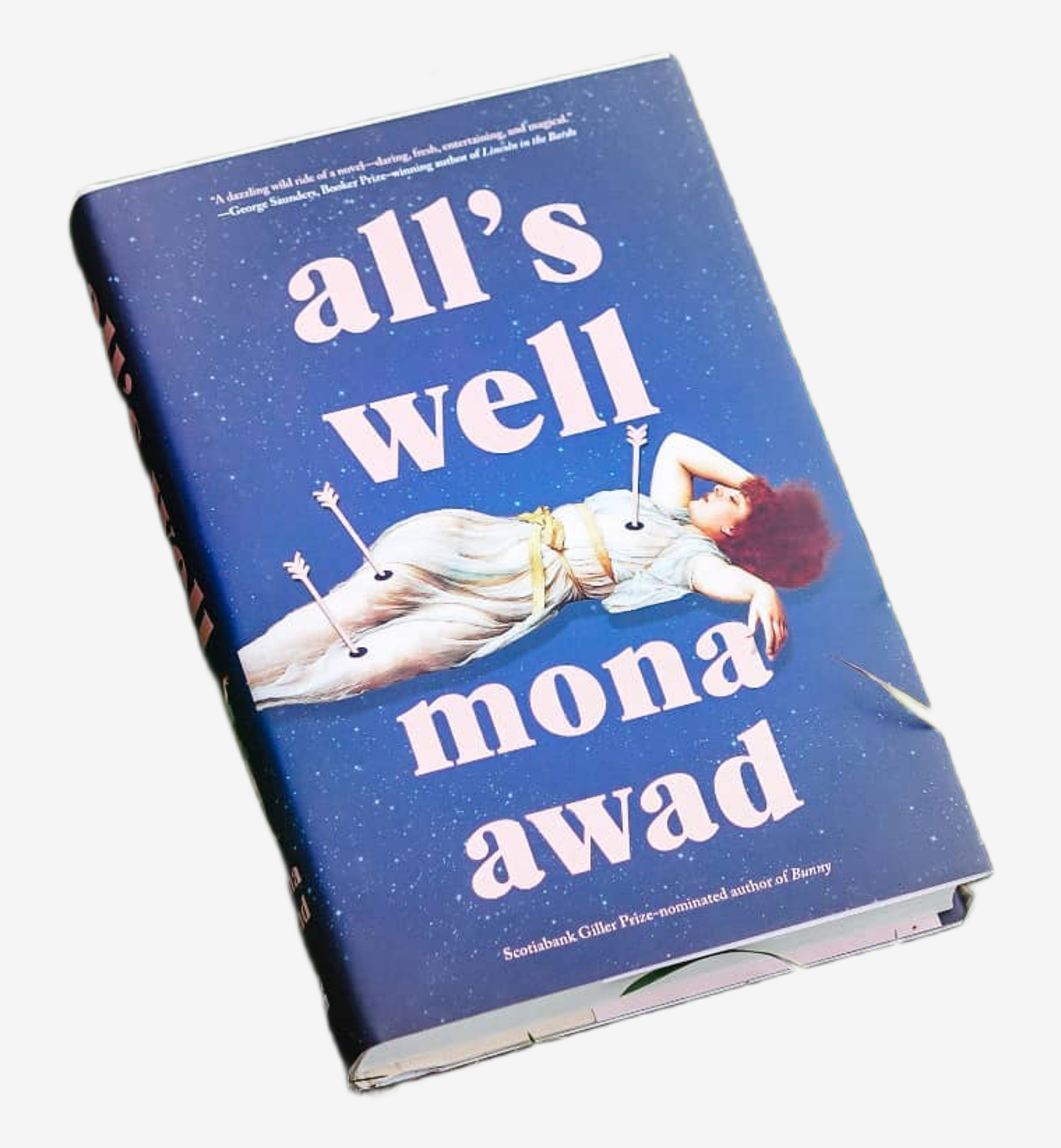 Hardcover edition of All’s Well by Mona Awad (author and title in baby pink text against a navy blue, starry night sky background. In the center, a white woman with red hair wearing a sheer white gown with three gold rope belts is draped across the text, laying on her back with three baby pink arrows sticking out from her—one in each leg and one in the heart)