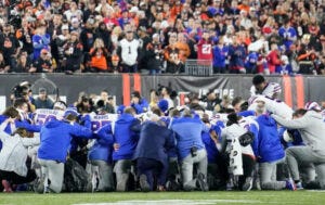 Buffalo Bills kneel to pray for Damar Hamlin after he experienced cardiac arrest and collapsed on the field during a game against the Cincinnati Bengals on Monday, January 2, 2023 (Tampa Bay Times).