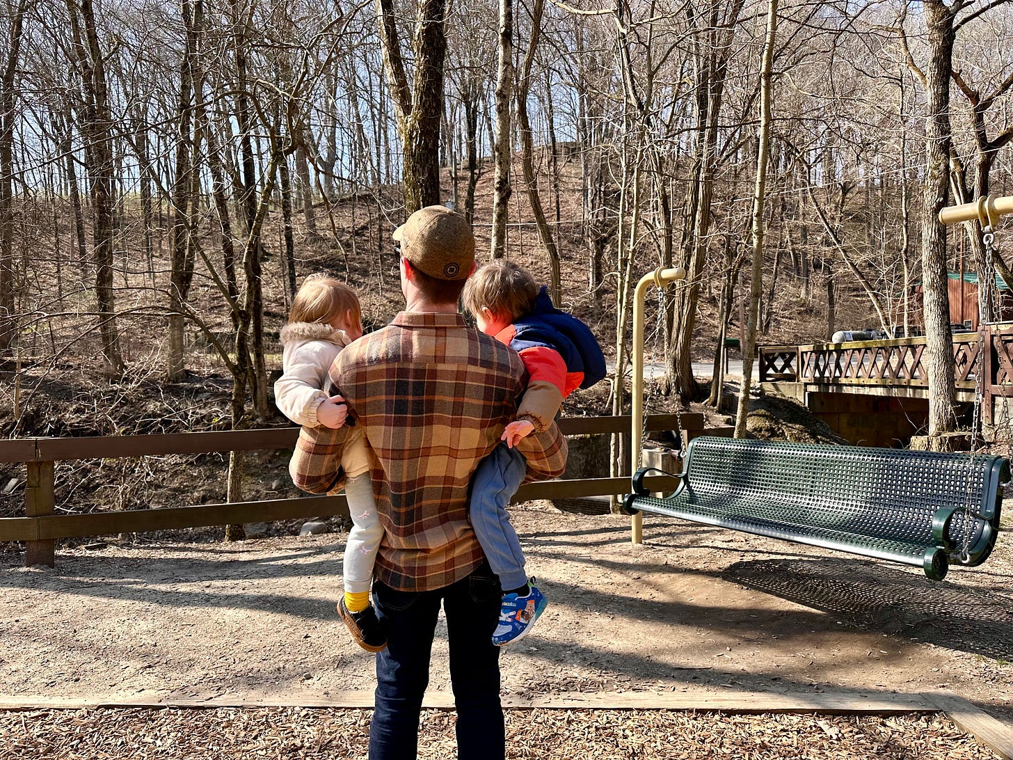 Jacob at the park holding his two kids