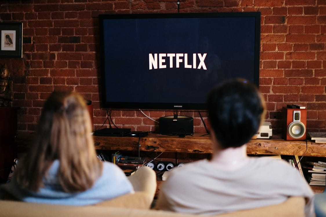 Free A couple relaxing and watching Netflix in a cozy living room setting. Stock Photo