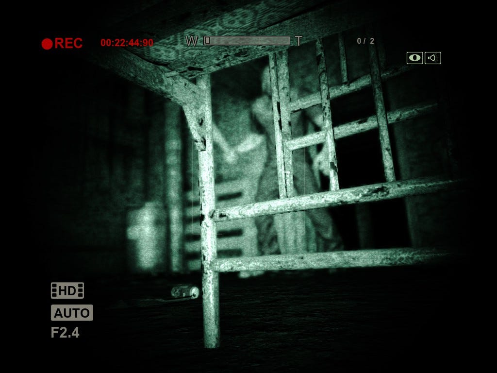 A screenshot from the player's perspective of hiding under a bed in Outlast. Beyond the bedframe, we can see a man carrying a blunt instrument appearing to search for the player.