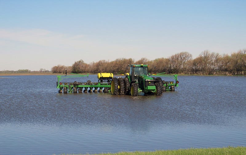 A tractor crosses a completely flooded field.