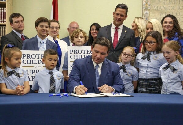 FILE - Florida Gov. Ron DeSantis signs the Parental Rights in Education bill, also known as the "Don't say gay," bill, at Classical Preparatory School, on March 28, 2022, in Shady Hills, Fla. DeSantis' divisive education policies have faced wide criticism from civil rights leaders and professional educators, among others, but they also have paid off politically. (Douglas R. Clifford/Tampa Bay Times via AP, File)