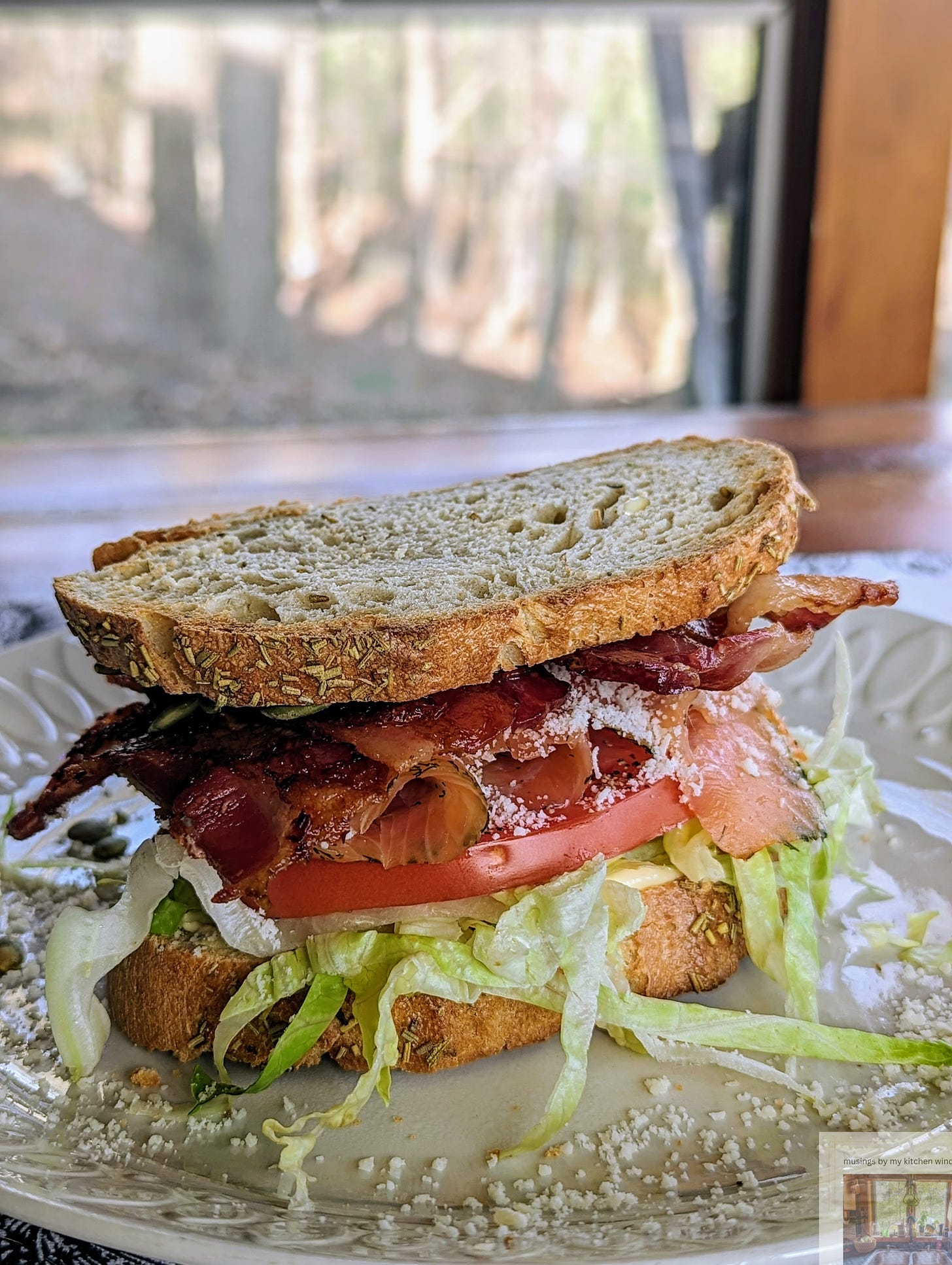A juicy BLT is stacked high with lettuce, tomato, and bacon between toasted rosemary bread.