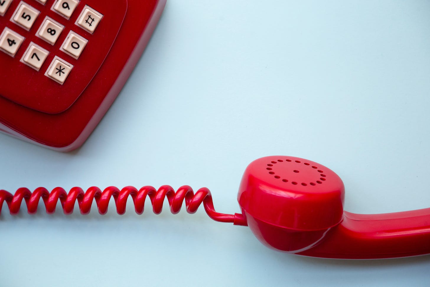 red rotary phone with red cord