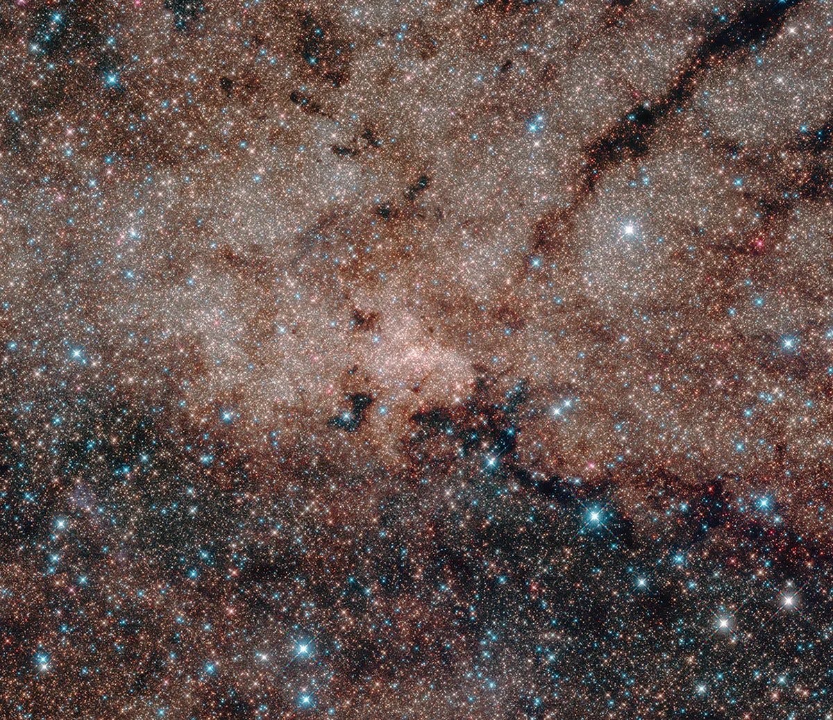 Hubble's infrared vision pierced the dusty heart of our Milky Way galaxy to reveal more than half a million stars at its core. At the very hub of our galaxy, this star cluster surrounds the Milky Way's central supermassive black hole, which is about 4 million times the mass of our sun. | NASA, ESA, and Hubble Heritage Team (STScI/AURA, Acknowledgment: T. Do, A.Ghez (UCLA), V. Bajaj (STScI)