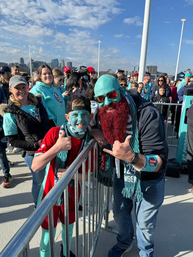 Photo of Teal Man and a young boy with his face painted teal too