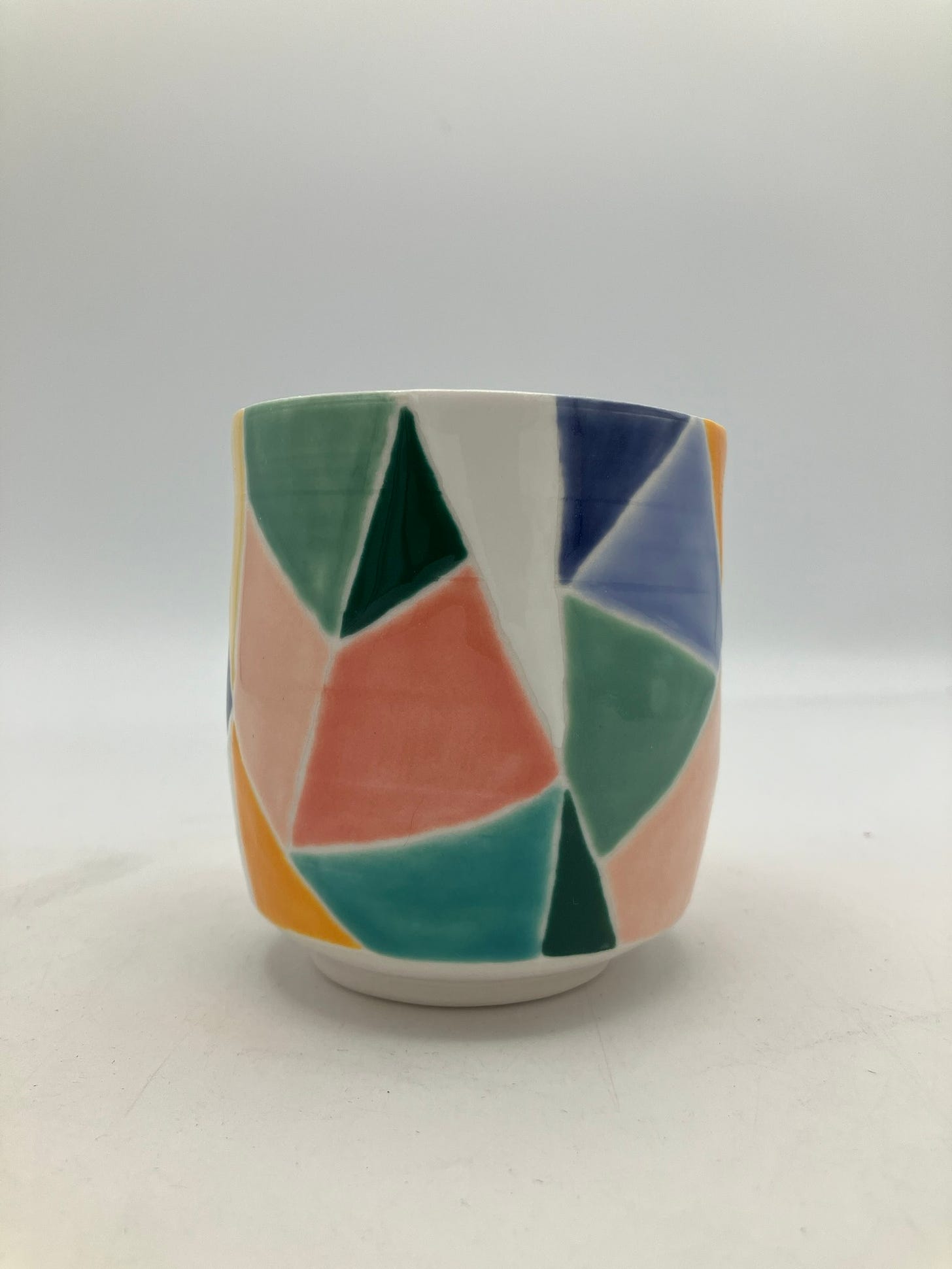 multicolored porcelain cup with teal and pink triangles