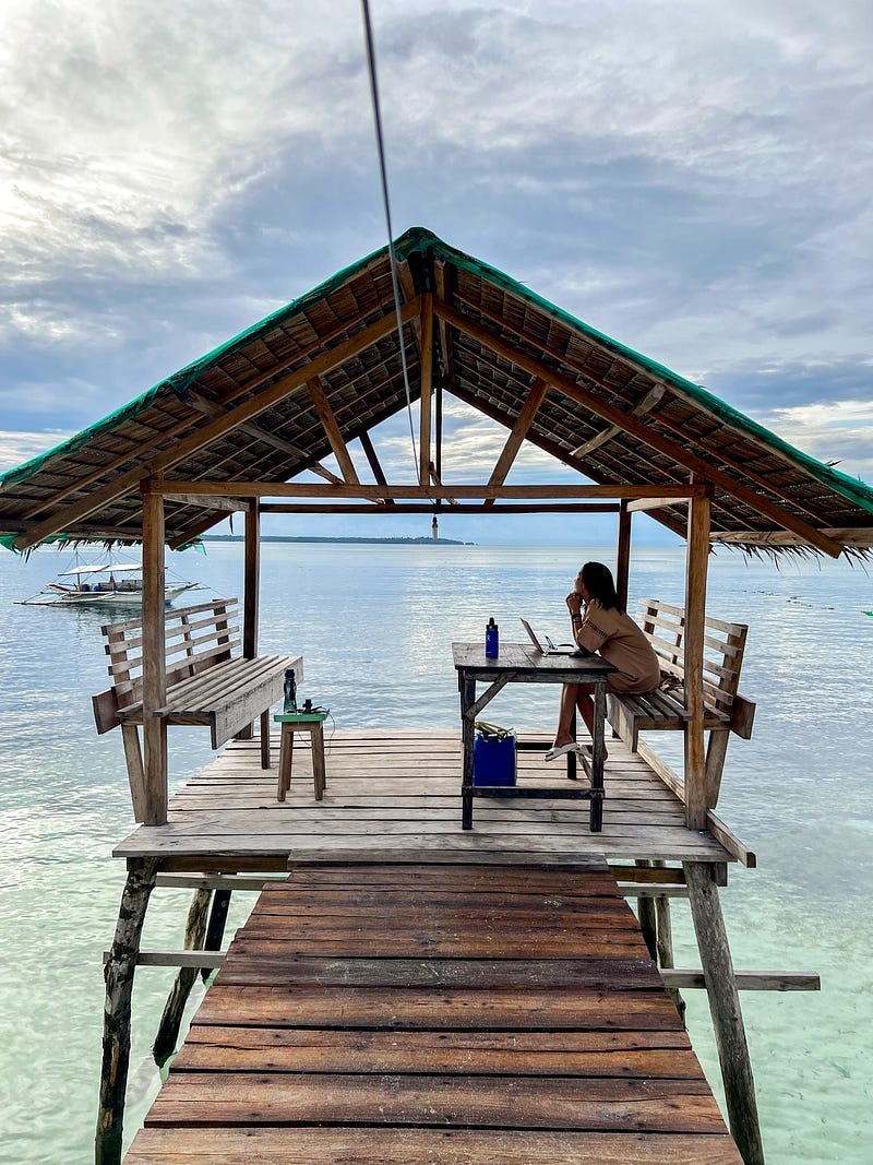 Girl on a stilted nipa hut, staring out to the sea