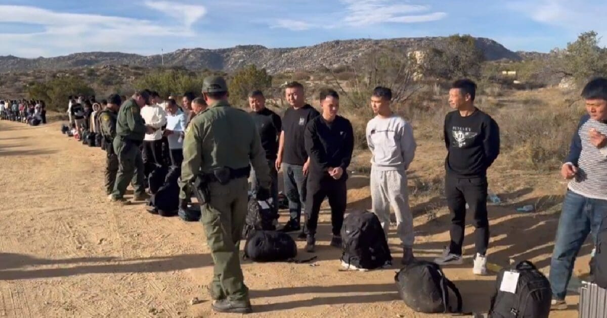 Large group of Chinese male migrants with smart luggage illegally cross ...