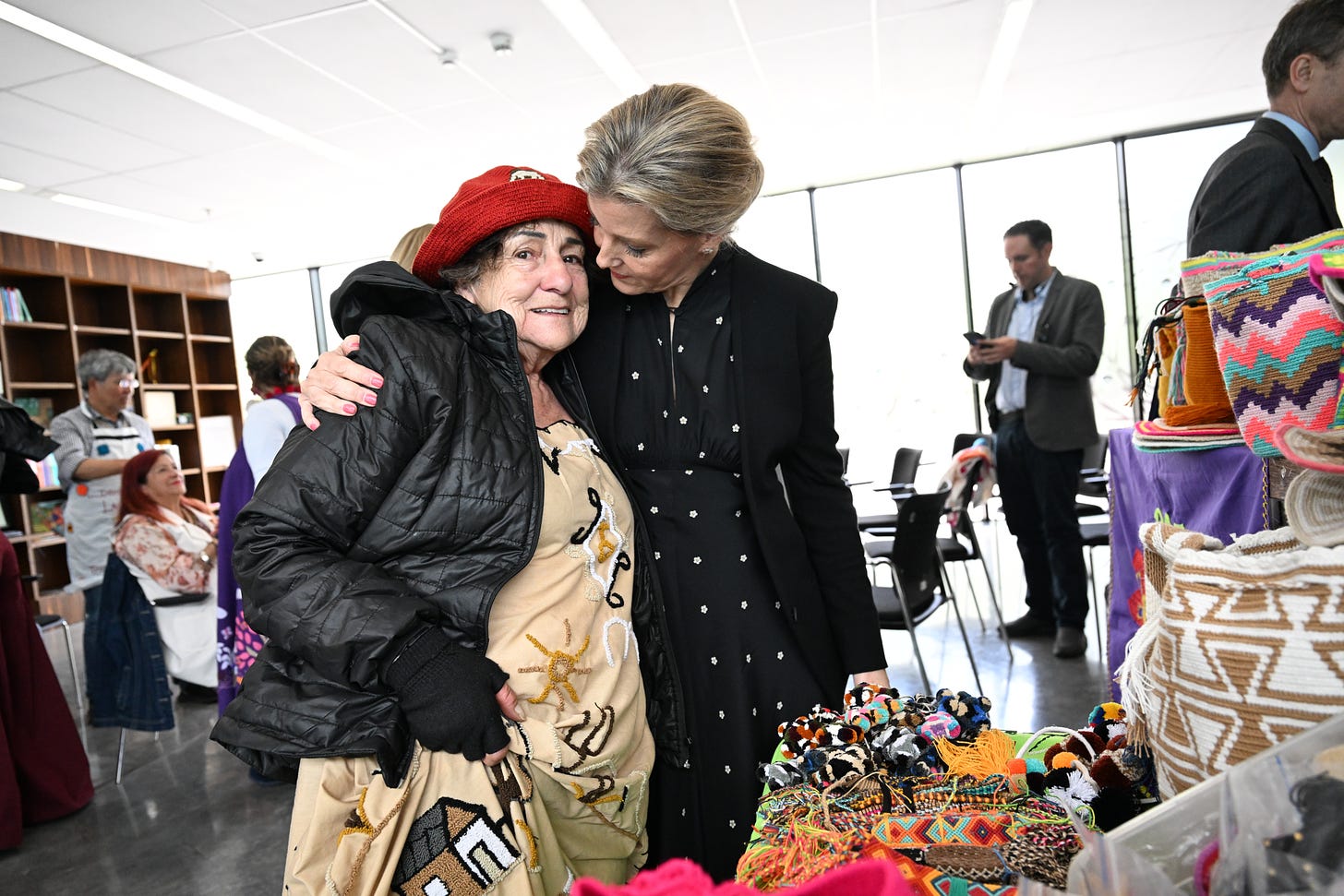 Duchess Sophie hugging a woman in a red hat