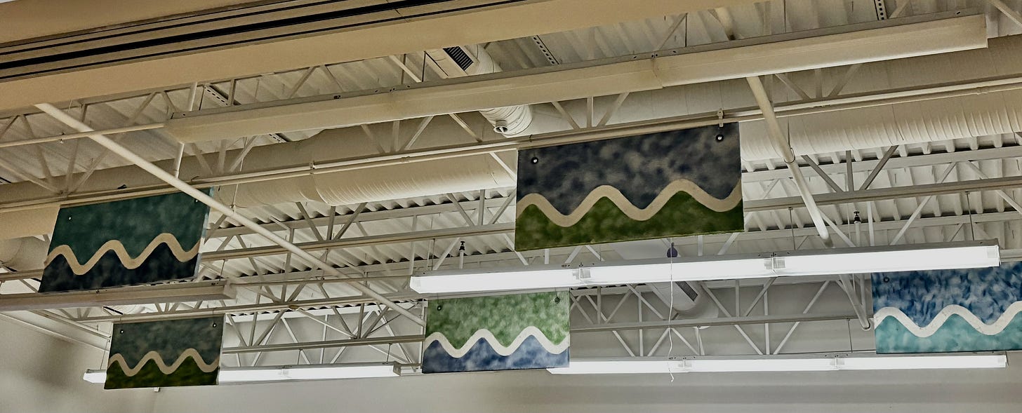 Ceiling with structural beams and rectangles painted with white waves over blue and green colors