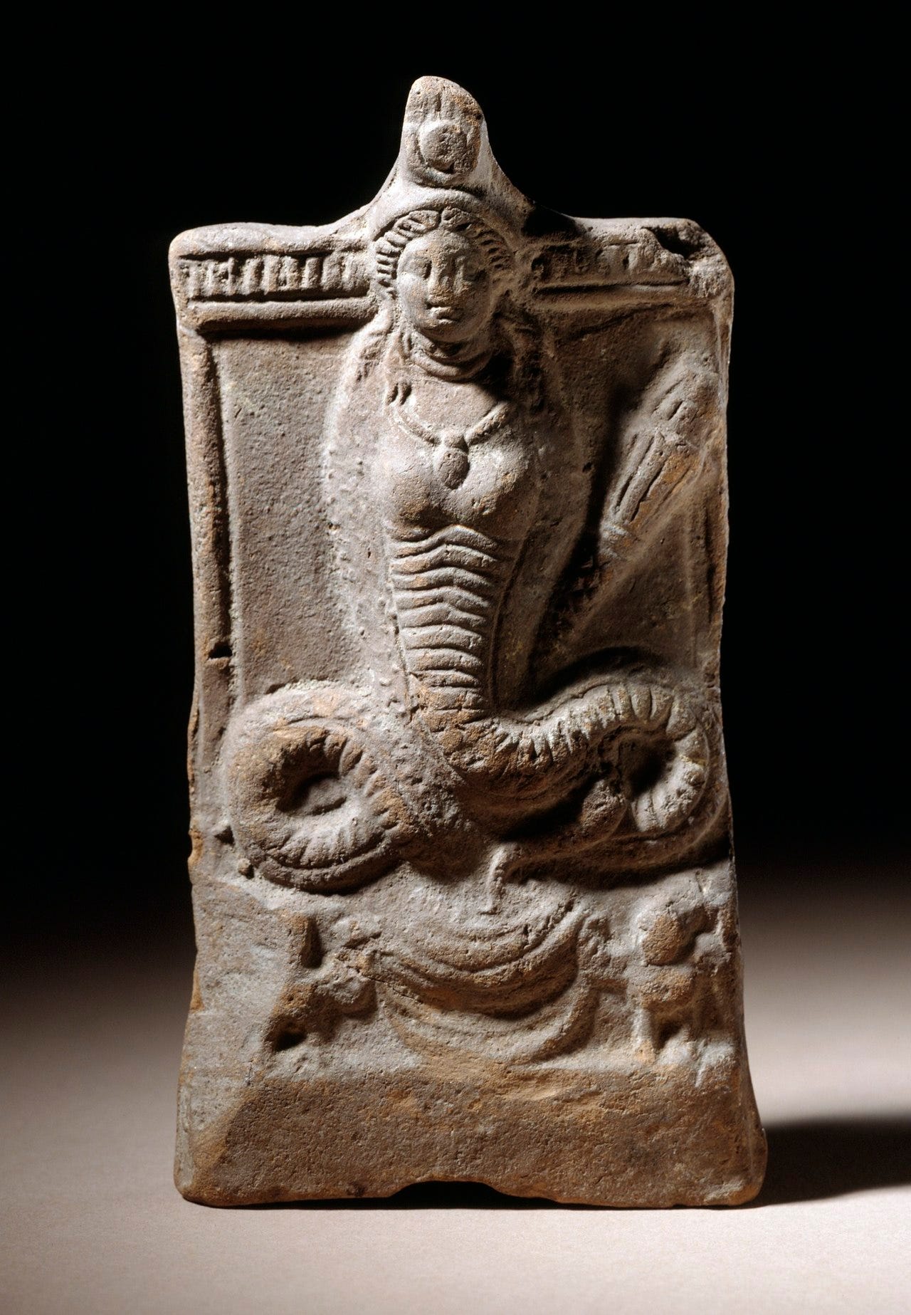 Statue of a snake with the upper torso and head of a woman