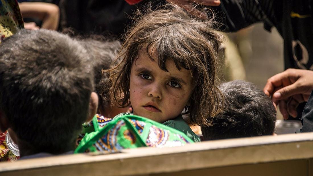 Iraqi children wait to be relocated after fleeing the fighting between government forces and Islamic