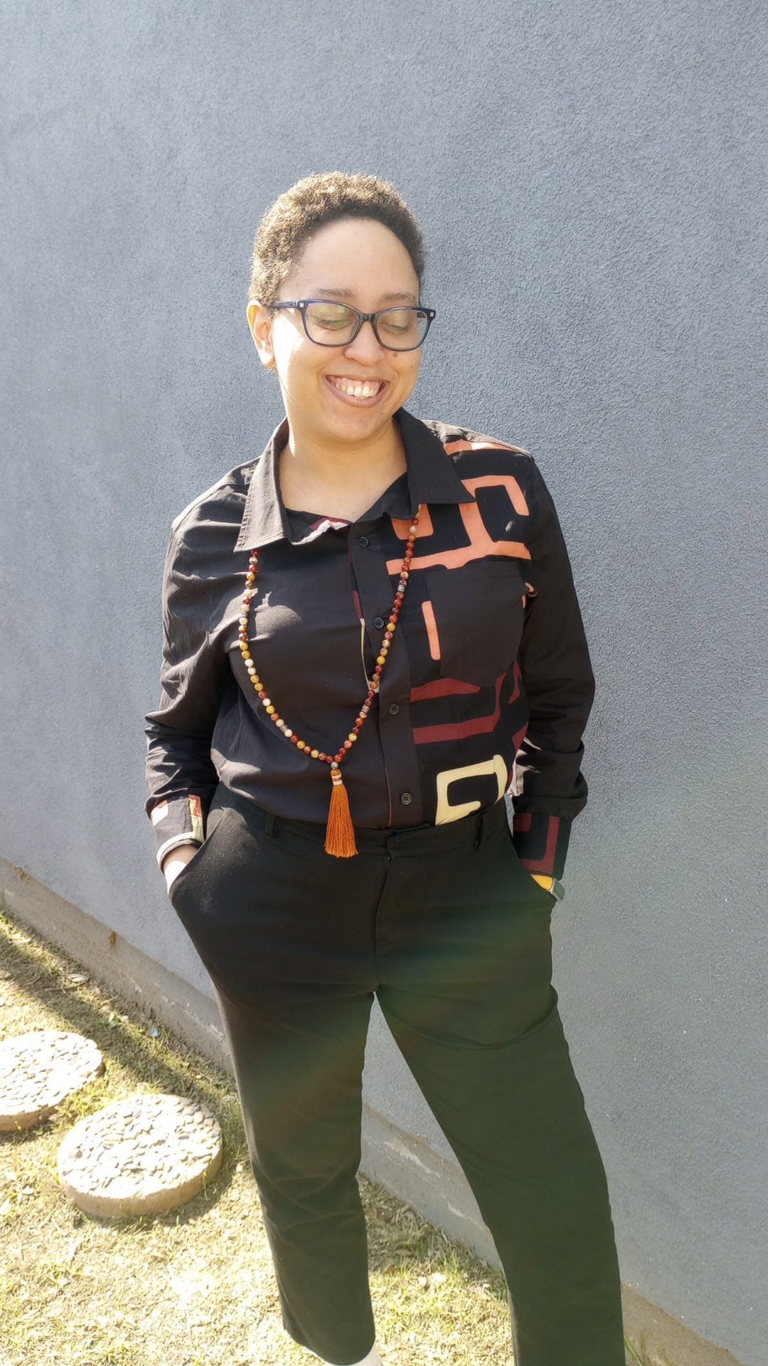 A picture of Karen A. Parker in a black shirt with their back against the warm, shining sun