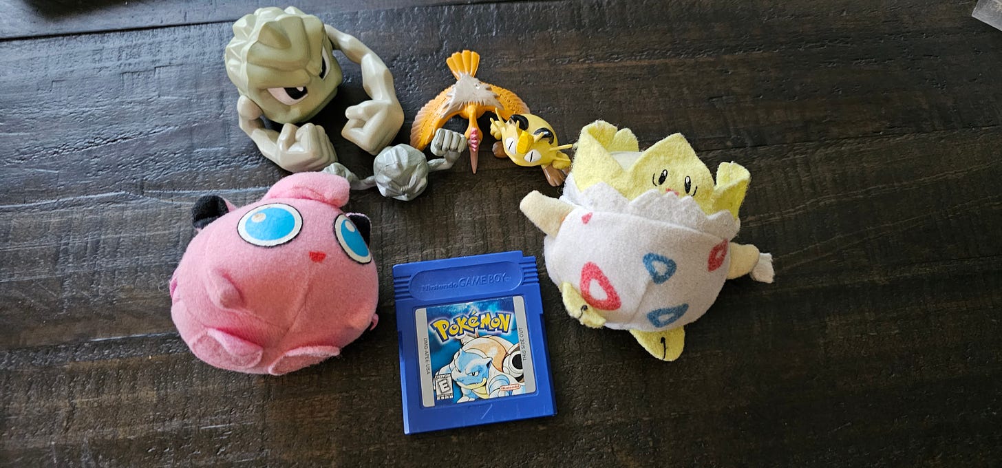 Yui’s original Pokémon Blue, along with Geodude, Fearow and Meowth figures, Jigglypuff and Togepi plush toys