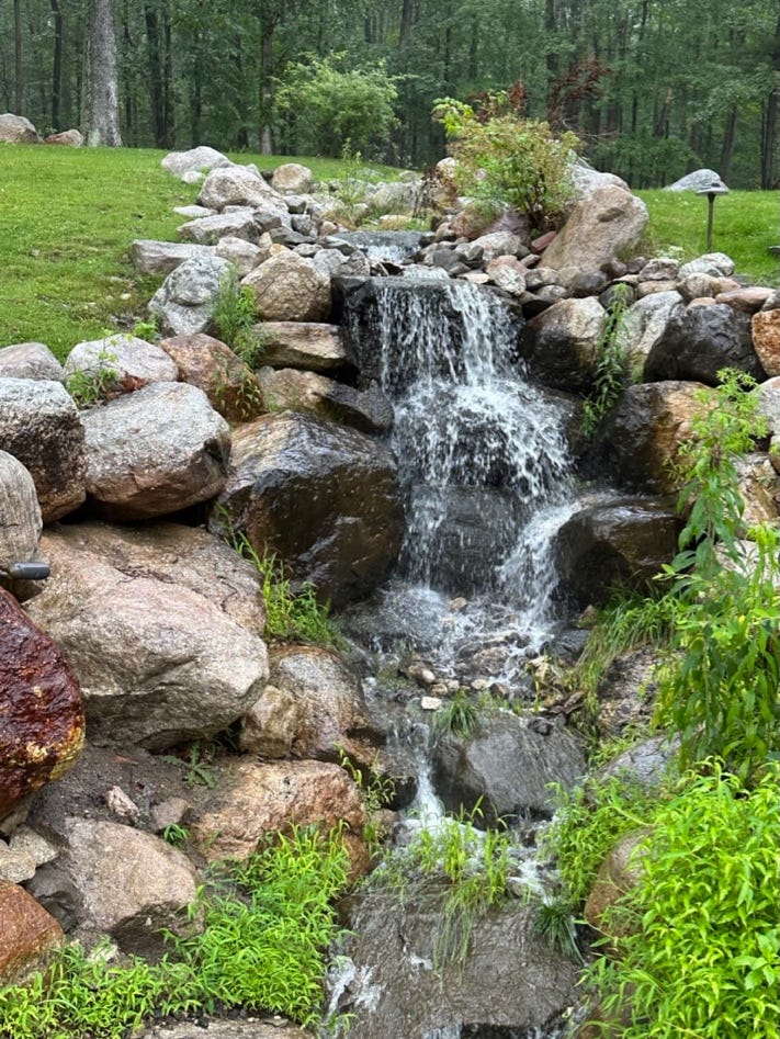 A waterfall in a park

Description automatically generated