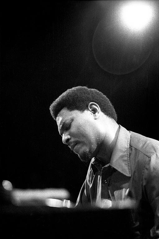 McCoy Tyner at the piano with a spotlight over his head