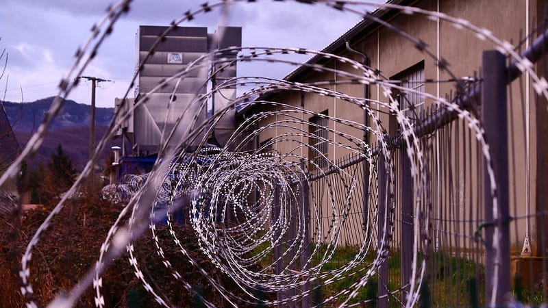 a barbed wire fence outside of a prison