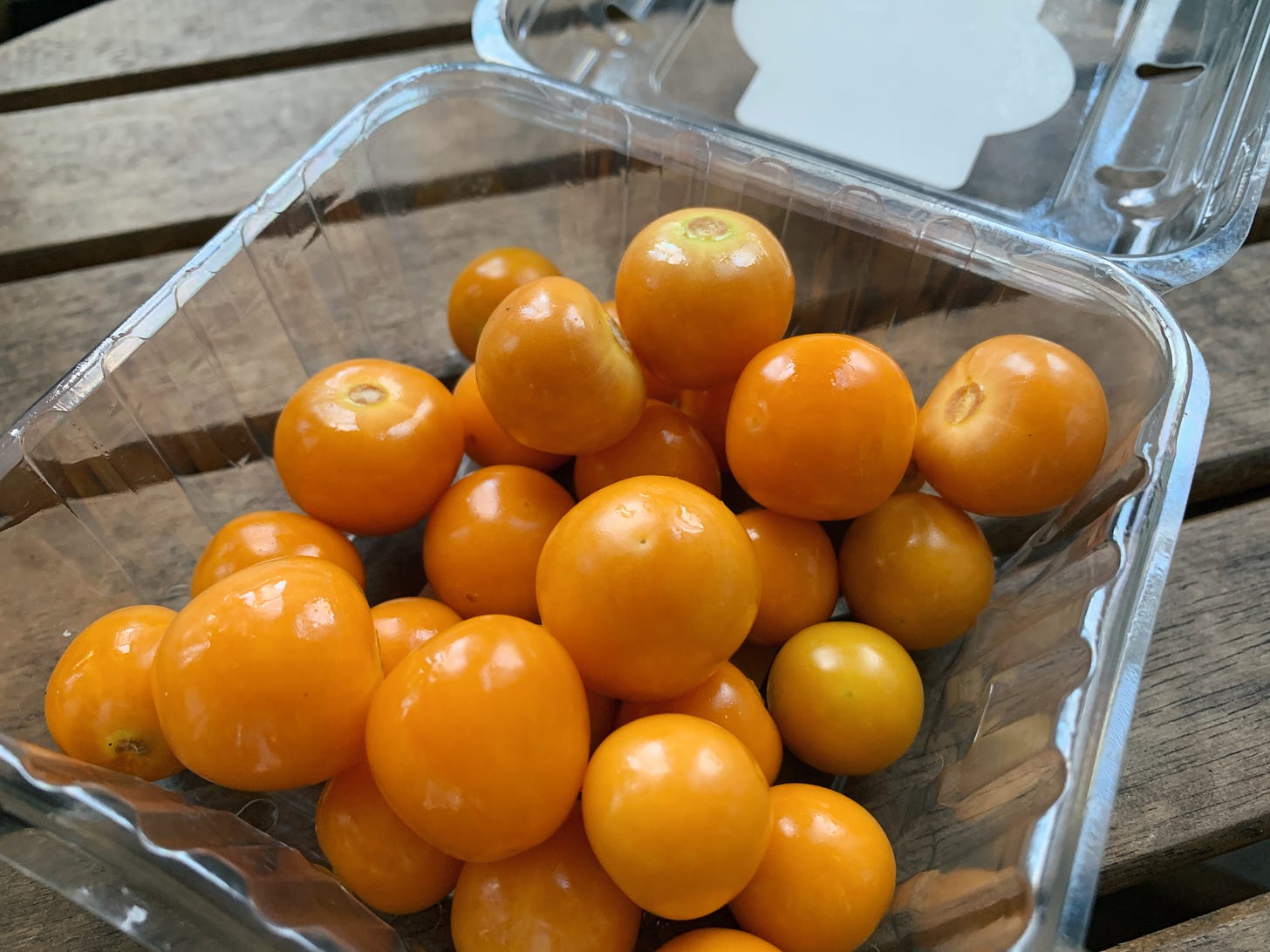 An opened plastic box full of bright gooseberries (also known as golden berries).