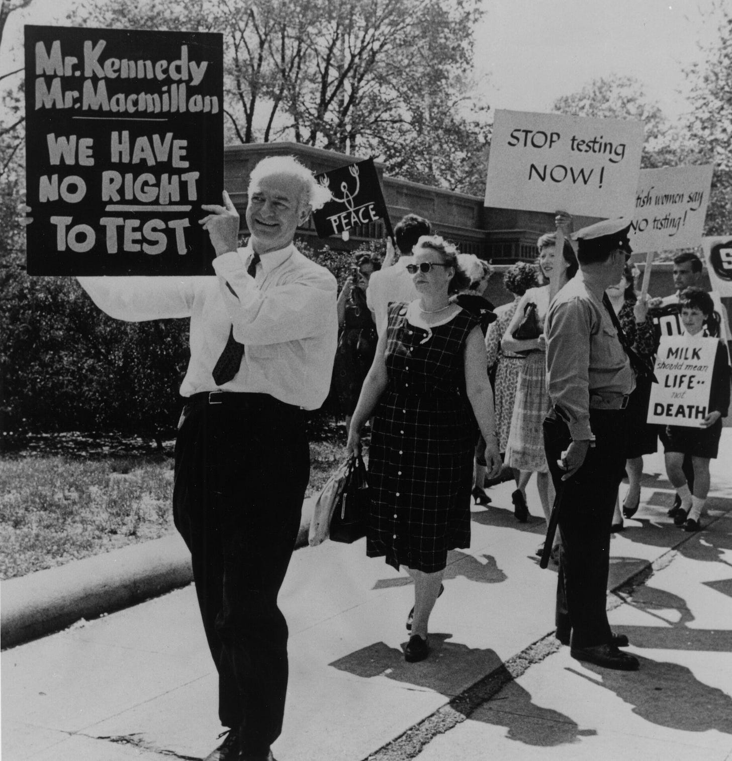 Linus Pauling, 1954 Nobel prize winner for chemistry, holds up a sign opposing atmospheric nuclear testing at a rally near the White House, April 28, 1962. (AIP Emilio Segrè Visual Archives)