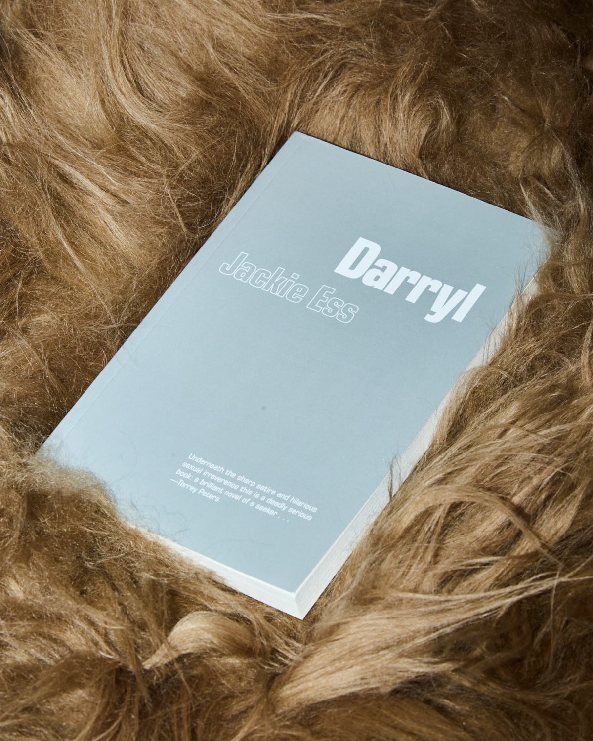 A copy of Darryl lies on a bed of fur or hair. The cover is silver and reads: Darryl, Jackie Ess