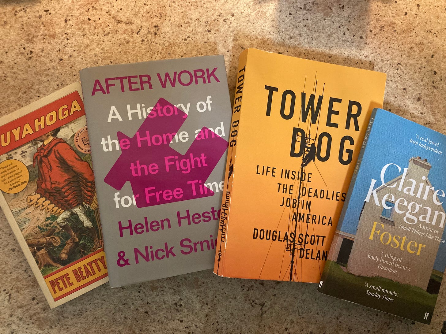 Photograph of copies of four books: Cuyahoga by Pete Beatty, After Work: A History of the Home and the Fight for Free Time by Helen Hester and Nick Srnicek, Tower Dog: Life Inside the Deadliest Job in America by Douglas Scott Delaney, and Foster by Claire Keegan.