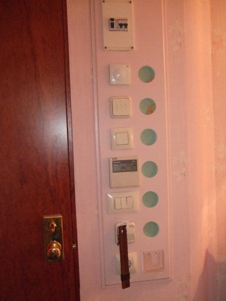 A wall with multiple light switches