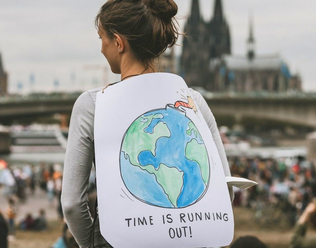 a woman holding a sign that says time is running out a woman holding a sign that says time is running out