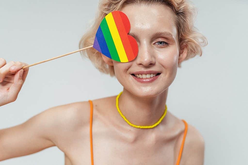A woman is smiling and promoting LGBTQ and defiling the rainbow.