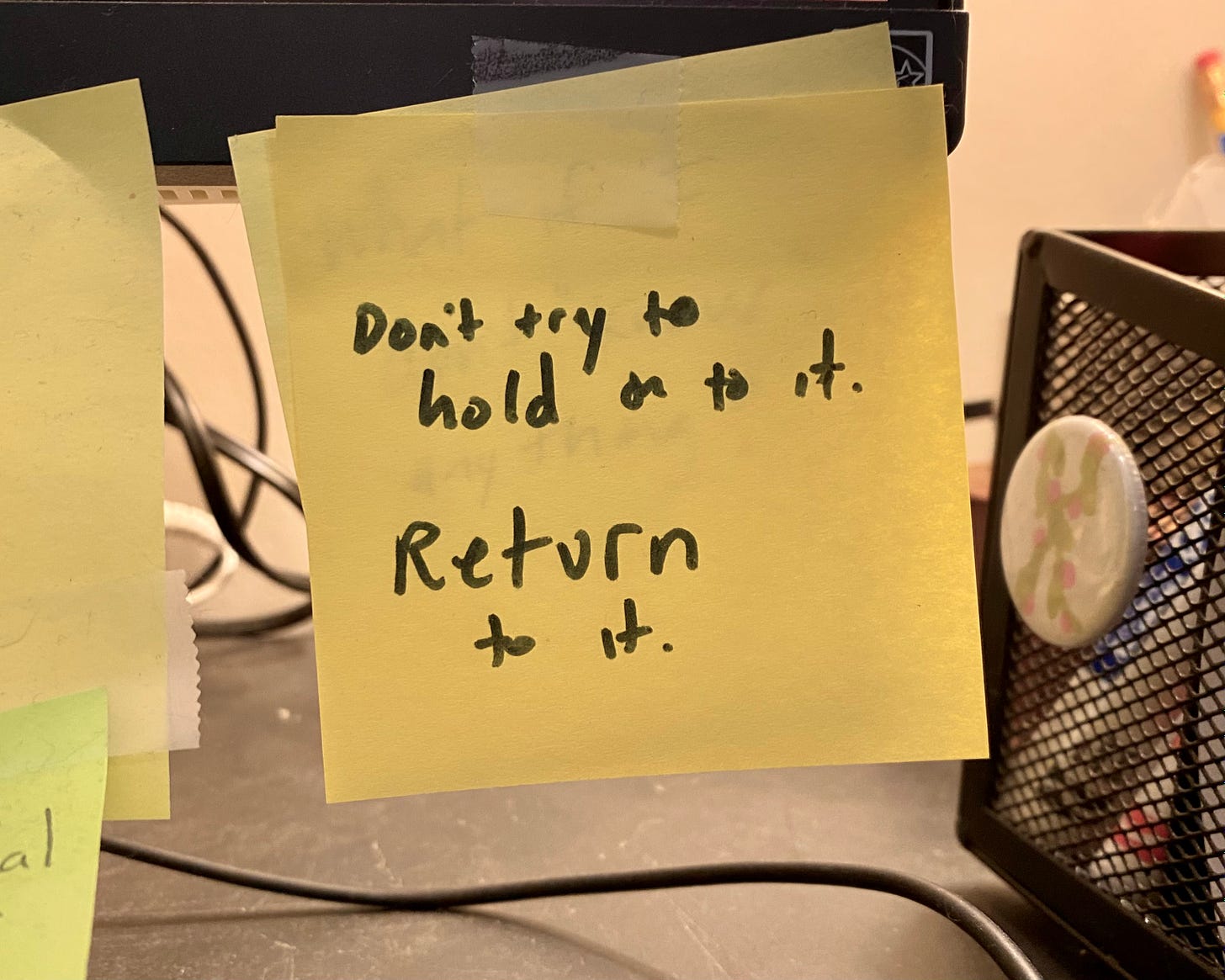 sticky note with handwritten words Don't try to hold onto it. Return to it. 
