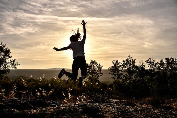 A woman jumping at the top of a mountain. A woman jumping at the top of a mountain.