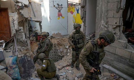 Israeli soldiers stand at the entrance of a tunnel, among the rubble of a damaged building, where the military says six Israeli hostages were recently killed by Hamas militants.