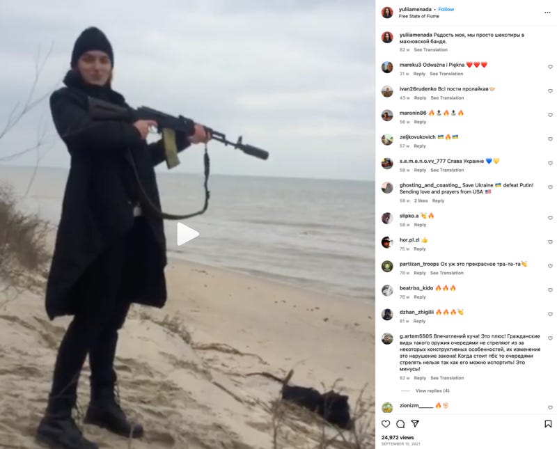 A woman firing a rifle on a beach