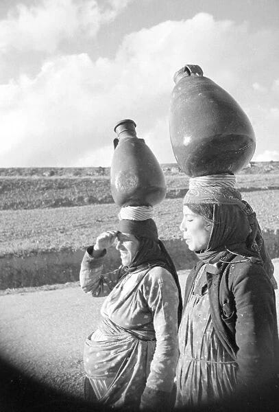 Two Arab women carrying water jars on their head For sale as Framed Prints,  Photos, Wall Art and Photo Gifts