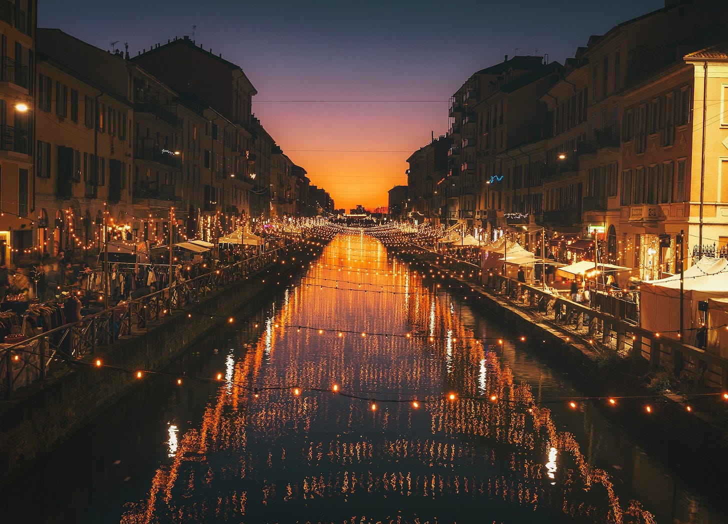 Canal bordé de bars en fête à la tombée du jour