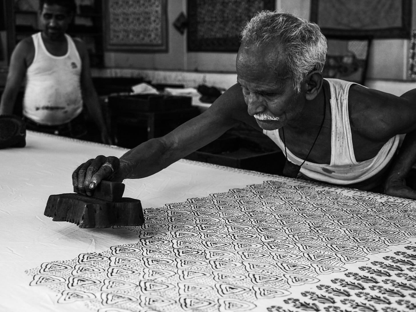 Man stamping repeating patterns on a white surface
