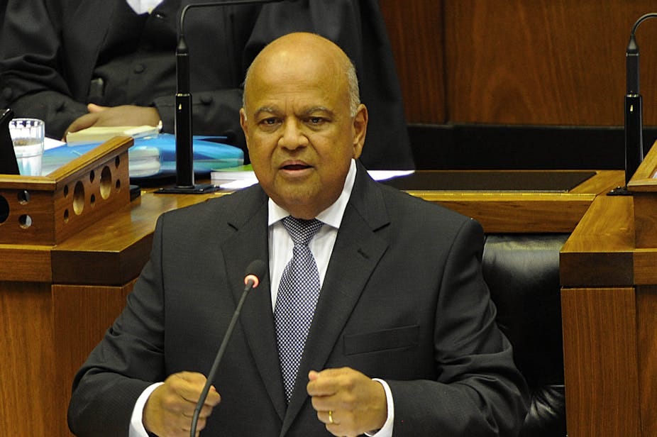 A man wearing a suit speaks at a podium.